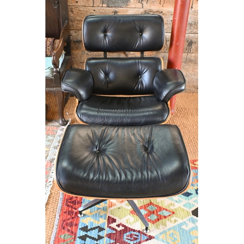 131 - A classic Eames style swivel armchair to/with a matching footstool, buttoned black leather and plywo... 