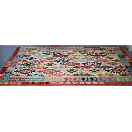 A contemporary Turkish Kelim carpet, the multi-coloured diamond design on camel ground, 296 cm x 200 cm