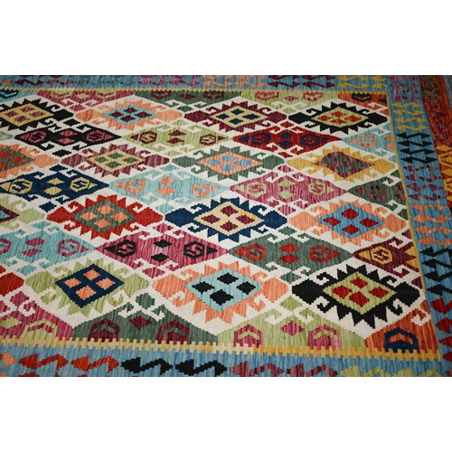 132 - A contemporary Turkish Kelim carpet, the multi-coloured diamond design on camel ground, 296 cm x 200... 