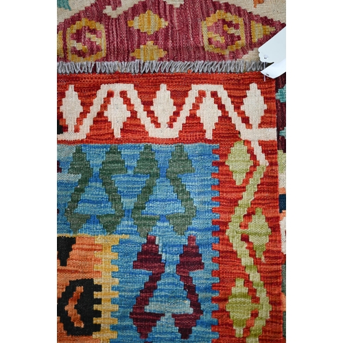 132 - A contemporary Turkish Kelim carpet, the multi-coloured diamond design on camel ground, 296 cm x 200... 