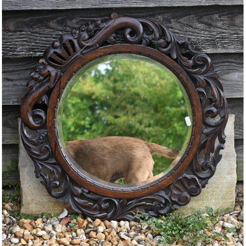 134 - A carved oak demi-lune side table, 77 cm w x 76 cm h to/w a circular oak fret-cut wall mirror, 56 cm... 