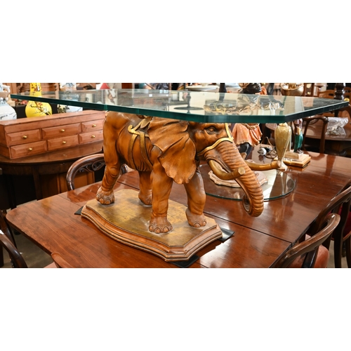 34 - A glass-topped coffee table supported by a carved and gilded wood elephant, to/w a side-table suppor... 