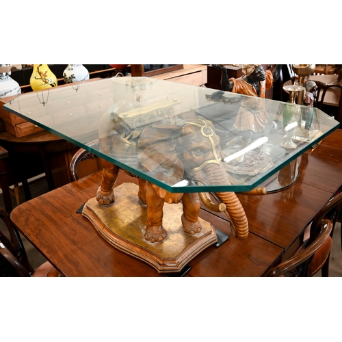 34 - A glass-topped coffee table supported by a carved and gilded wood elephant, to/w a side-table suppor... 