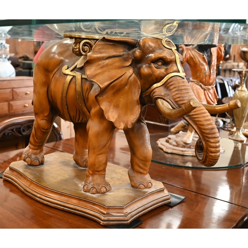 34 - A glass-topped coffee table supported by a carved and gilded wood elephant, to/w a side-table suppor... 