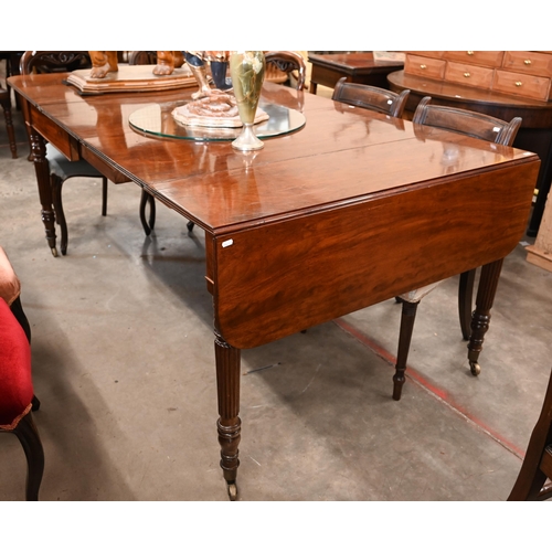 35 - A Regency telescopic dining table with drop ends and two leaf inserts, on turned and reeded supports... 