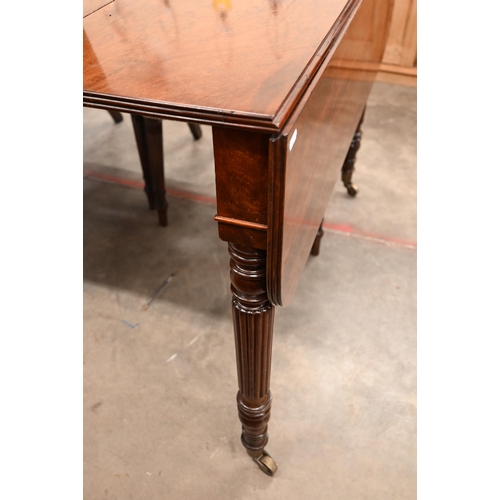 35 - A Regency telescopic dining table with drop ends and two leaf inserts, on turned and reeded supports... 