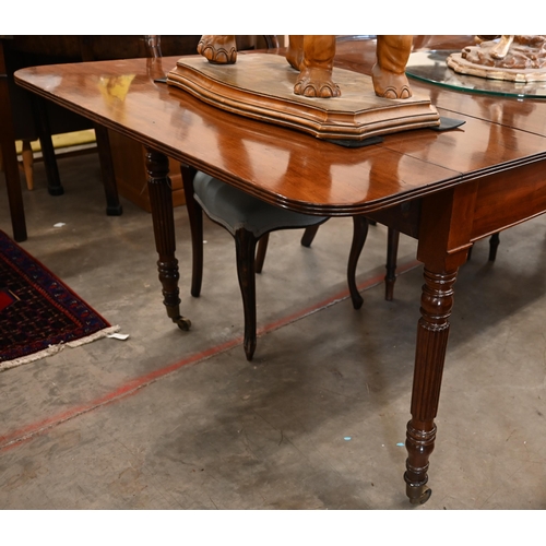 35 - A Regency telescopic dining table with drop ends and two leaf inserts, on turned and reeded supports... 