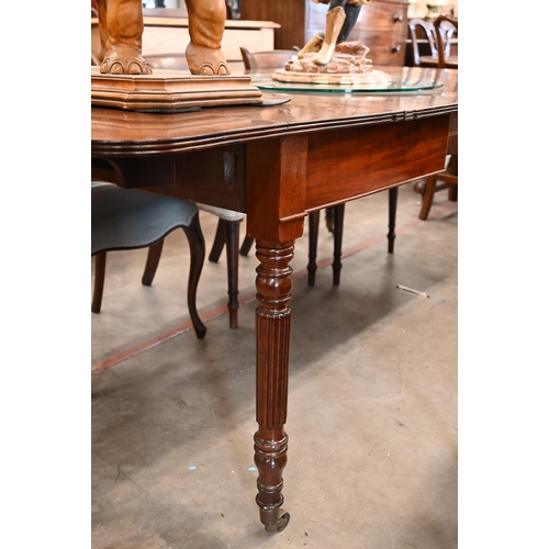 35 - A Regency telescopic dining table with drop ends and two leaf inserts, on turned and reeded supports... 