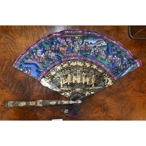 457 - An antique Cantonese fan with gilded black lacquer sticks and painted paper leaf decorated on both s... 