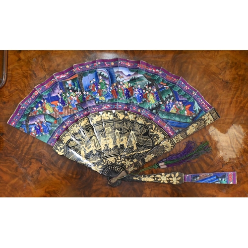 457 - An antique Cantonese fan with gilded black lacquer sticks and painted paper leaf decorated on both s... 