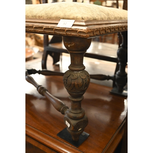 52 - An oak long stool/window seat with padded top on carved supports with cross stretcher, 11 cm