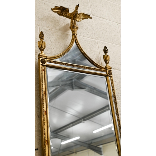 56 - A gilt framed wall mirror surmounted by a spread eagle flanked by urns, 124 x 51 cm