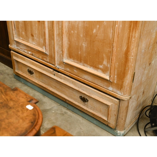 58 - A Victorian stripped pine wardrobe with twin panelled doors and long base drawer, 128 cm wide