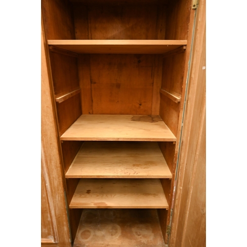 58 - A Victorian stripped pine wardrobe with twin panelled doors and long base drawer, 128 cm wide