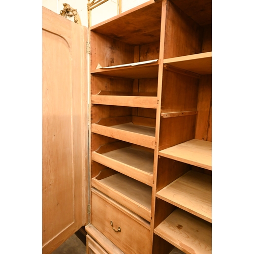 58 - A Victorian stripped pine wardrobe with twin panelled doors and long base drawer, 128 cm wide