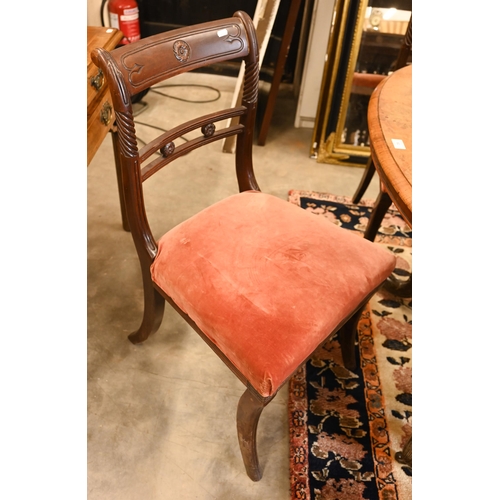 62 - A set of four Regency mahogany dining chairs with carved backs and stuff over seats, on sabre suppor... 