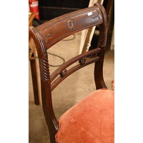 62 - A set of four Regency mahogany dining chairs with carved backs and stuff over seats, on sabre suppor... 