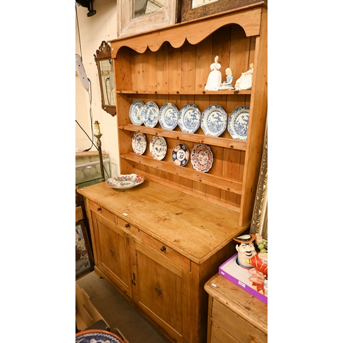 66 - A vintage waxed pine dresser with plate rack over three drawers and panelled cupboard doors, 140 cm ... 