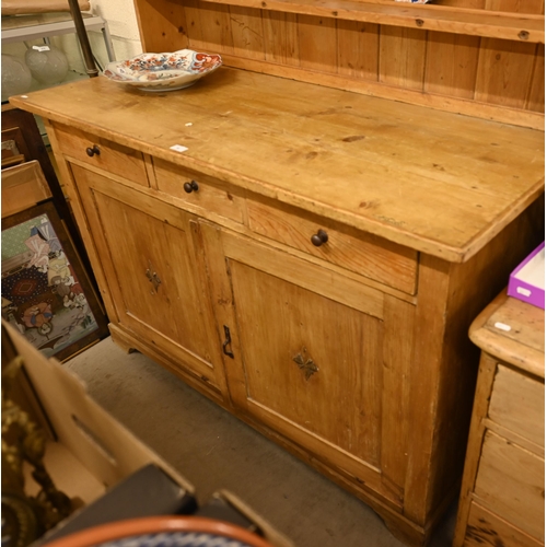 66 - A vintage waxed pine dresser with plate rack over three drawers and panelled cupboard doors, 140 cm ... 