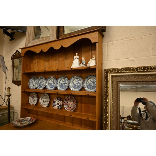 66 - A vintage waxed pine dresser with plate rack over three drawers and panelled cupboard doors, 140 cm ... 