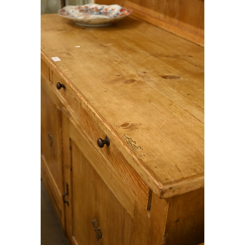 66 - A vintage waxed pine dresser with plate rack over three drawers and panelled cupboard doors, 140 cm ... 