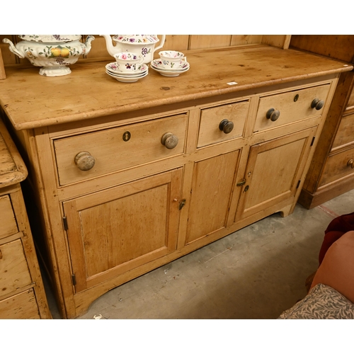 67 - A vintage pine dresser with plate rack over a panelled base with cupboards and three drawers, 145 cm... 