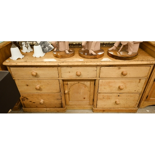 72 - A pine inverted breakfront sideboard with seven drawers surrounding the central panelled cupboard, 1... 