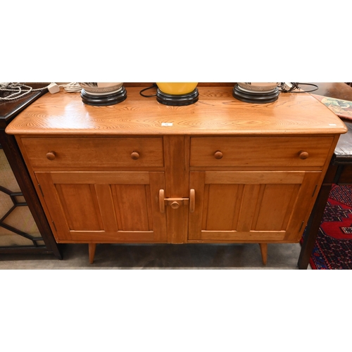 77 - A mid-century Ercol elm and beech sideboard with two drawers and panelled cupboards raised on splaye... 