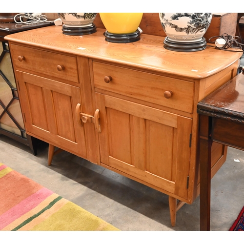 77 - A mid-century Ercol elm and beech sideboard with two drawers and panelled cupboards raised on splaye... 