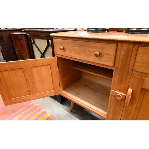 77 - A mid-century Ercol elm and beech sideboard with two drawers and panelled cupboards raised on splaye... 