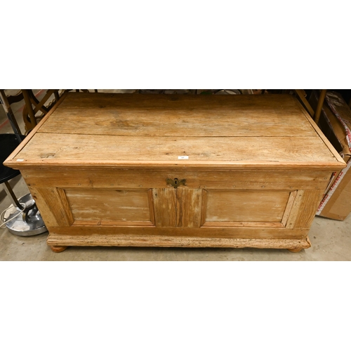 87 - A large pine blanket chest/trunk with hinged top and panelled front standing on turned bun feet, 122... 