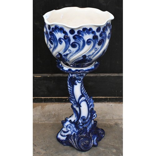 452 - An early 20th century blue and white jardiniere on stand, embossed with scrolling foliage, 85cm high