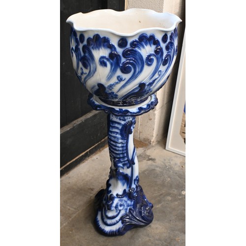 452 - An early 20th century blue and white jardiniere on stand, embossed with scrolling foliage, 85cm high