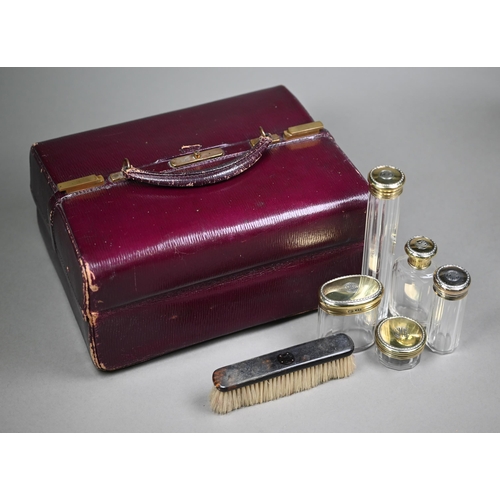 130 - An Asprey puce Morocco leather dressing case, fitted with five cut glass toilet jars - four with sil... 