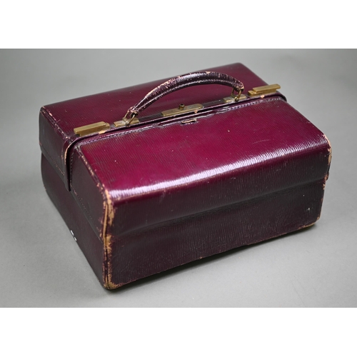 130 - An Asprey puce Morocco leather dressing case, fitted with five cut glass toilet jars - four with sil... 