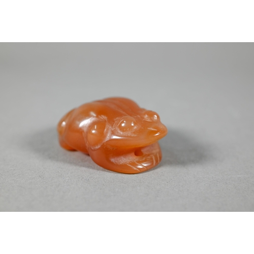 376 - A polished carnelian agate large pendant, 5.5 cm to/w a carved agate frog, 5.5 cm, a jadeite Buddha ... 