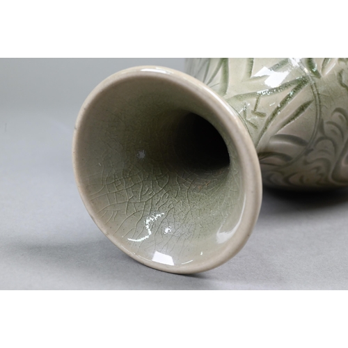 377 - A Chinese Yazhou Northern Celadon vase with incised floral and foliate decoration under the pale oli... 