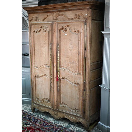 757 - An 18th/19th century French bleached oak armoire, the moulded cornice over a pair of moulded panelle... 