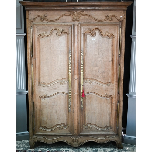 757 - An 18th/19th century French bleached oak armoire, the moulded cornice over a pair of moulded panelle... 