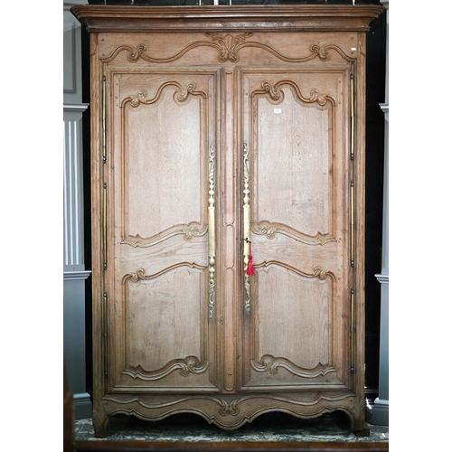 757 - An 18th/19th century French bleached oak armoire, the moulded cornice over a pair of moulded panelle... 
