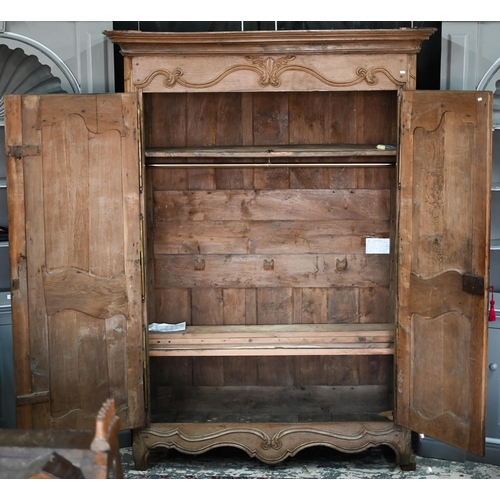 757 - An 18th/19th century French bleached oak armoire, the moulded cornice over a pair of moulded panelle... 