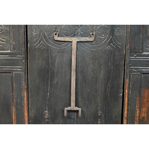 692 - A 17th century Welsh oak box settle, the crest rail with lunette carved decoration over further carv... 