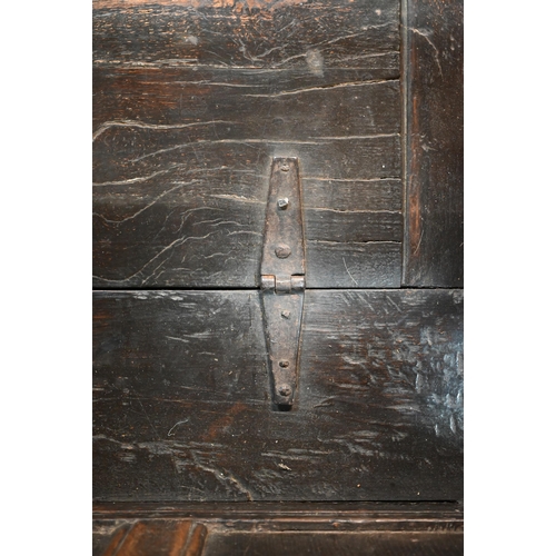 692 - A 17th century Welsh oak box settle, the crest rail with lunette carved decoration over further carv... 