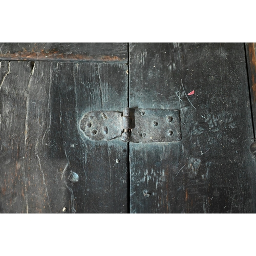 692 - A 17th century Welsh oak box settle, the crest rail with lunette carved decoration over further carv... 