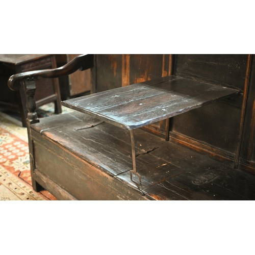 692 - A 17th century Welsh oak box settle, the crest rail with lunette carved decoration over further carv... 