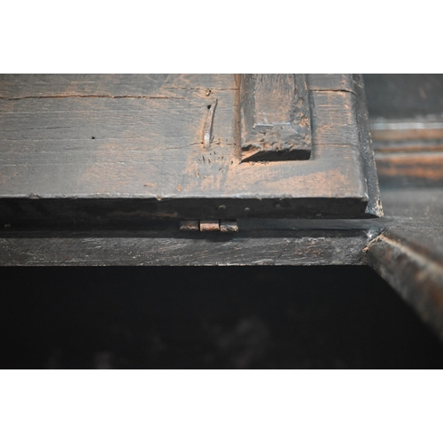 692 - A 17th century Welsh oak box settle, the crest rail with lunette carved decoration over further carv... 