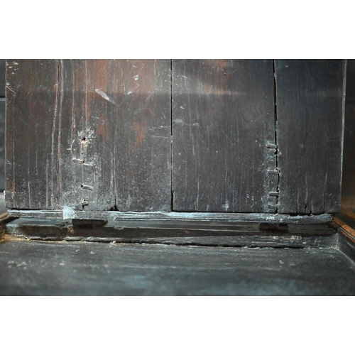 692 - A 17th century Welsh oak box settle, the crest rail with lunette carved decoration over further carv... 