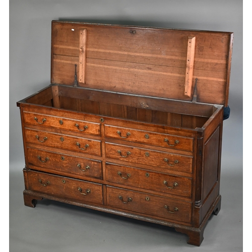 696 - An 18th century Lancashire oak mule chest, the twin plank hinged top over four dummy drawer fronts a... 