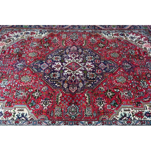 610 - A North West Persian Tabriz carpet, the coral-red ground centred by a medallion, 305 cm x 205 cm