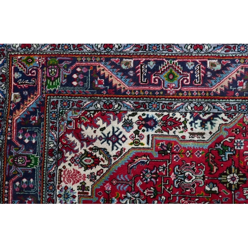 610 - A North West Persian Tabriz carpet, the coral-red ground centred by a medallion, 305 cm x 205 cm